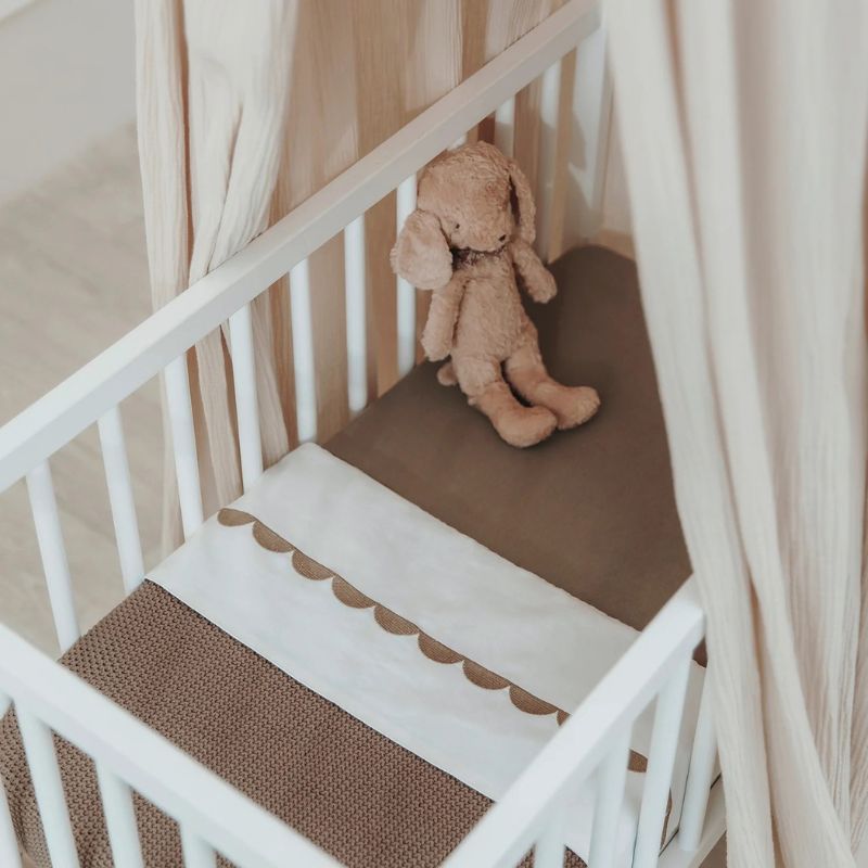 opgemaakt babybedje met taupe wieg en ledikantlaken meyco
